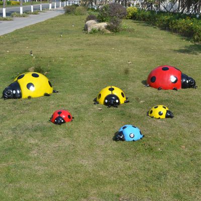 草地上擺放的大小不同的玻璃鋼彩繪瓢蟲雕塑