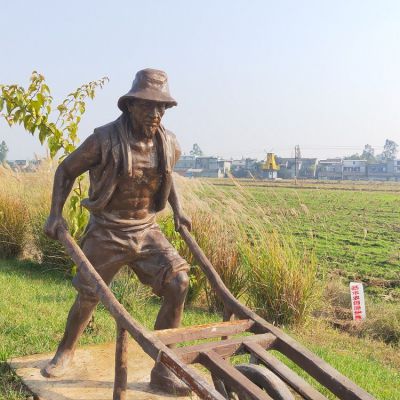 頭戴草帽，身穿坎肩，推獨輪車的老漢銅雕